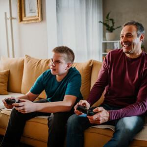 Smiling foster carer and child playing video games