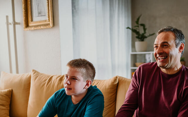 Smiling foster carer and child playing video games