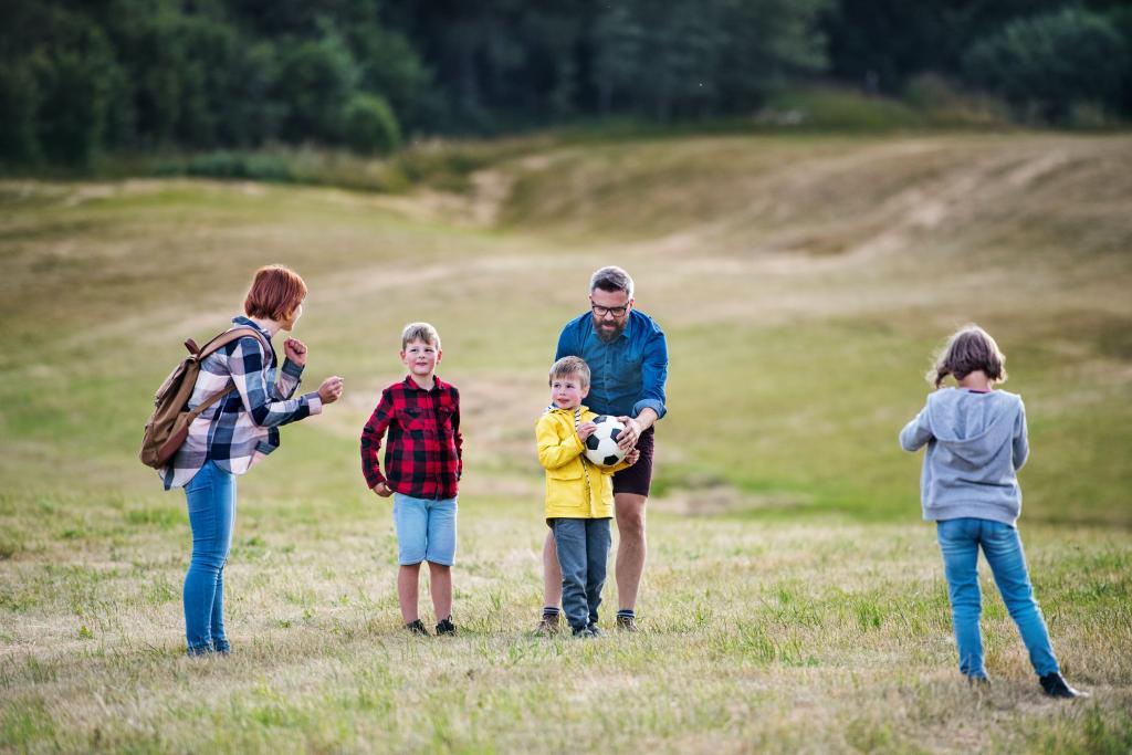 sessional worker playing with children in a field