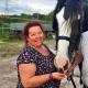 woman stroking black and white horse