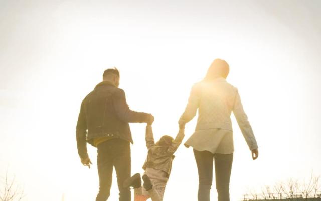 Foster parents lifting child while walking