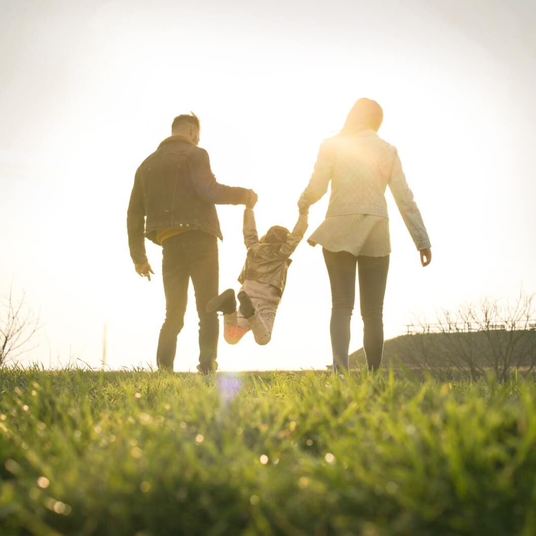 Foster parents lifting child while walking