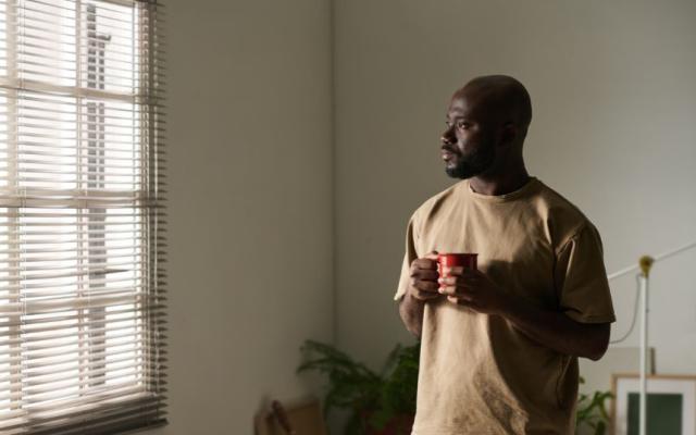 Representing emtpy nest syndrome and how to cope - a middle-aged man looking distractedly out of a window