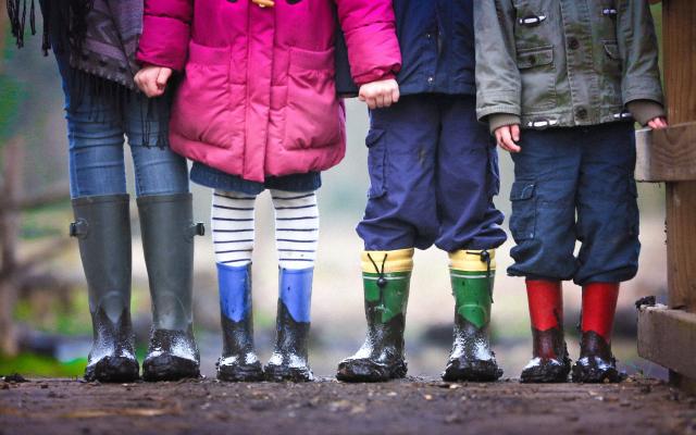 children holding hands and wearing wellies