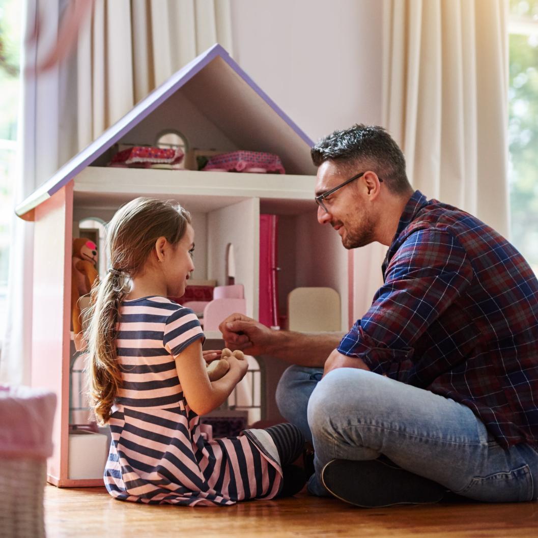 daughter and dad playing with dolls house