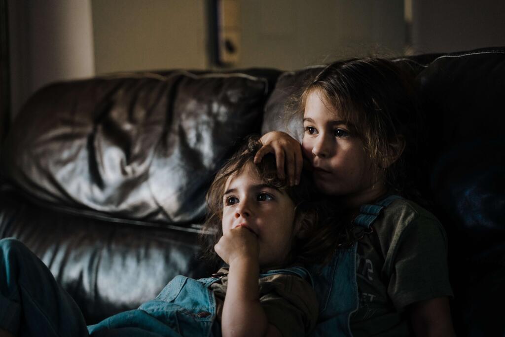 two foster children sat on sofa