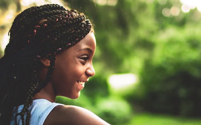 girl close to camera, smiling in a rural woodland setting