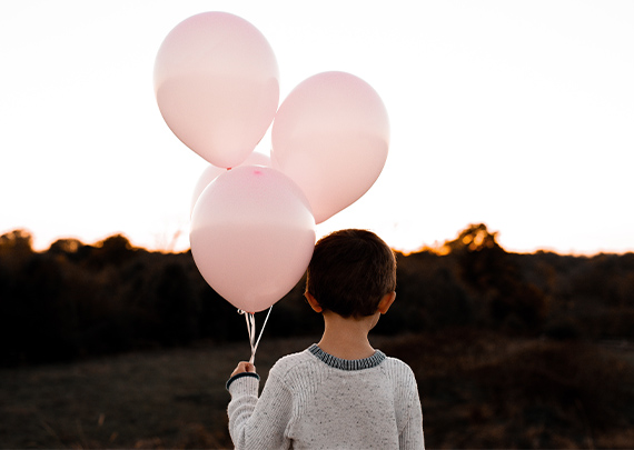 child with balloons illustrating foster carer birthday payment