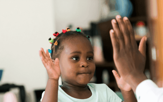 Young girl clapping a adults hand
