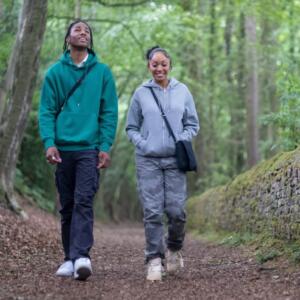 Two teenagers walking in woods
