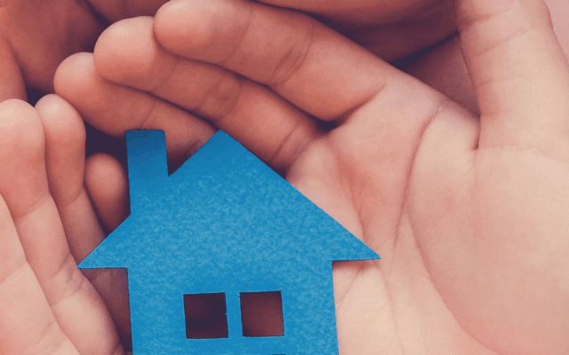Small paper house in hands