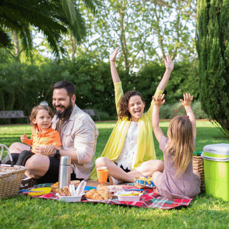 family smiling laughing outdoors having a picnic